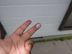 手で触れると白い粉が付着する劣化した外壁の様子